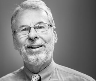 Black and white portrait of John Lorentz smiling.