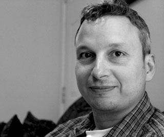 Black and white portrait of Nathan Lorentz smiling.